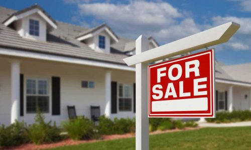 For Sale Real Estate Sign in Front of New House.